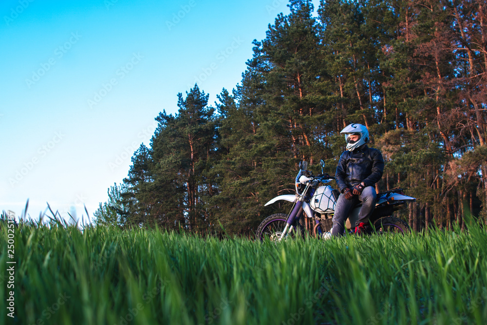 Obraz premium Motorcyclist on green grass off road, enduro, extreme sport, active lifestyle, adventure touring concept, enduro outdoor