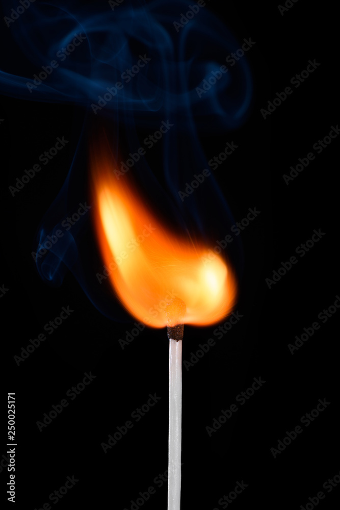 Burning match stick with fire and smoke isolated on black background