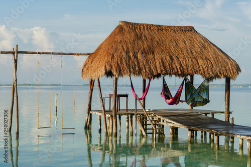 Konstfotografi A couple on hammocks under a palapa at Caribbean.