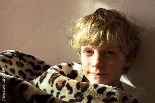 child boy wrapped in a blanket. looking at the camera.