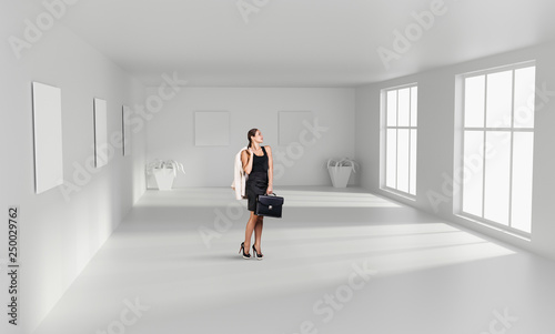 Realtor stands in the white empty room.