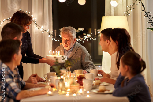 Canvas Print celebration and family concept - happy grandfather blowing candles on birthday c