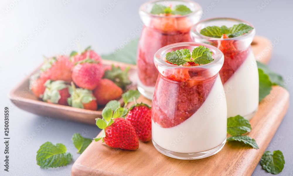 Delicous and nutritious double color (colour) strawberry desserts with mint and diced sarcocarp topping isolated with airy blue background, copy space, close up Delicous and nutritious double color (colour) strawberry desserts with mint and diced sarcocarp topping isolated with airy blue background, copy space, close up