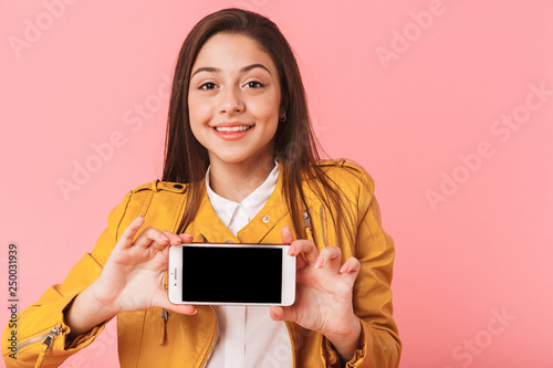 Happy young woman standing isolated over pink