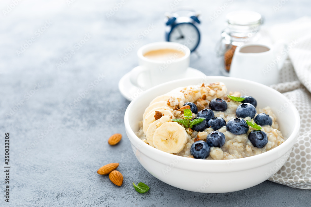 Oatmeal with fresh blueberry, banana, almond nuts and honey for breakfast