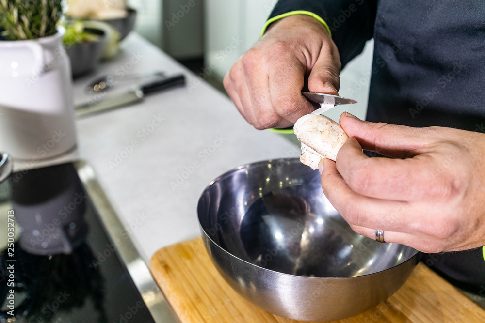 Chef peeling a mushroom in a kitchen Chef peeling a mushroom in a kitchen