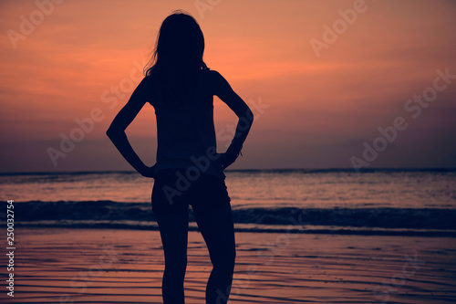 Silhouette of a girl in sunset / sunrise time over the ocean. © astrosystem