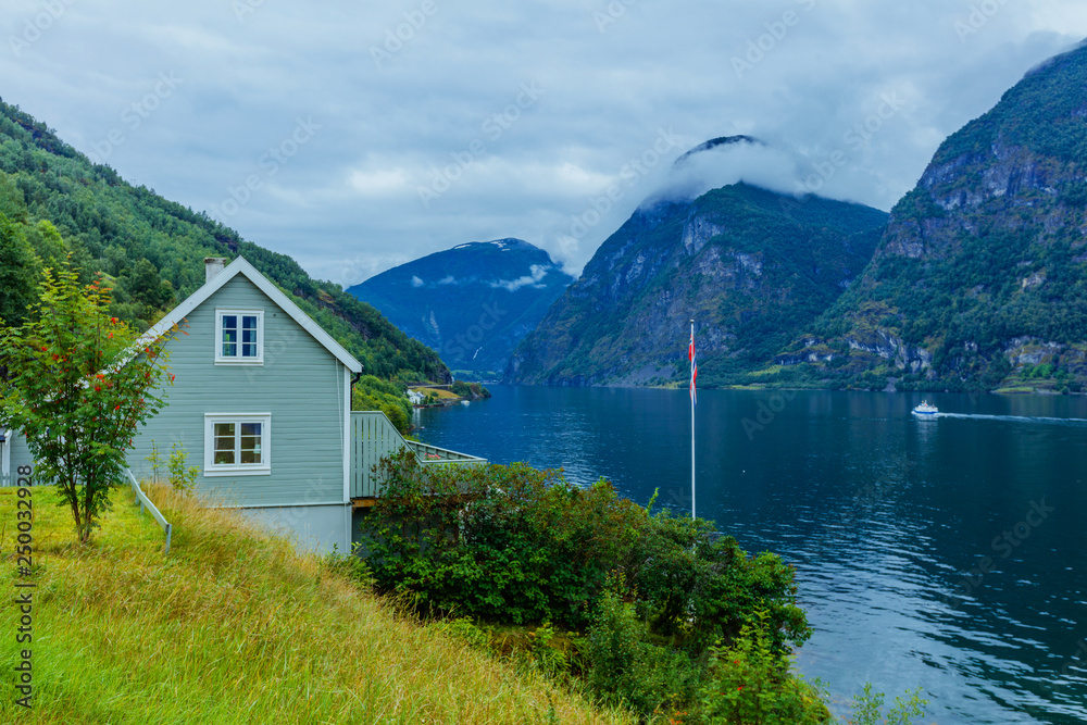 Typical countryside Norwegian landscape with green wall house. Cloudy summer morning in Norway, Europe.