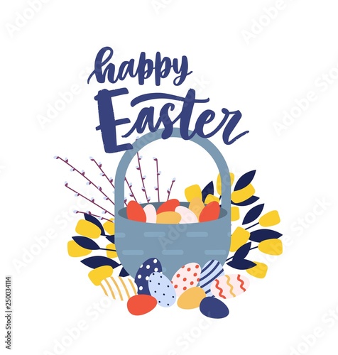 Greeting card template with Happy Easter wish handwritten with cursive calligraphic font and basket with decorated eggs, spring flowers and pussy willow branches