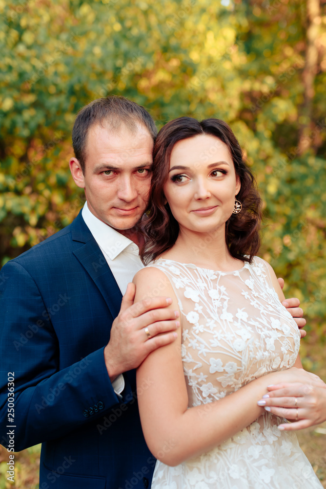 Fototapeta premium Młoda para spacerująca po jesiennym parku z żółtymi liśćmi