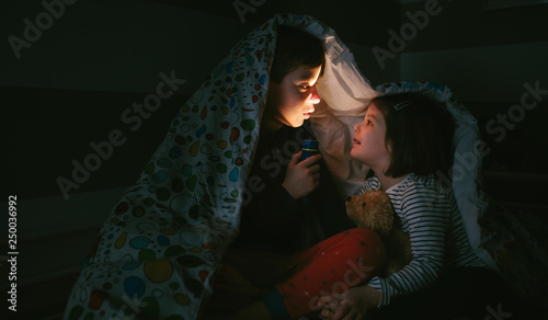 Boy telling a story of fear to his sister