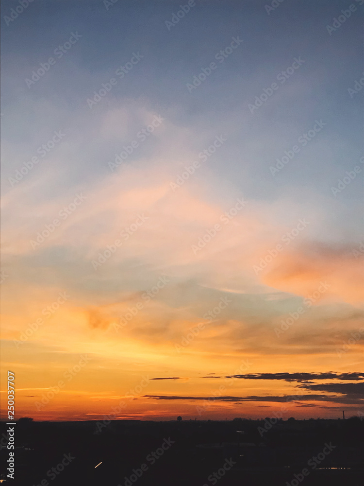 Beautiful amazing sunset, view of  city and sky. Blue and yellow sky with clouds, atmospheric scene of evening or morning. Dusk or dawn. Copy space