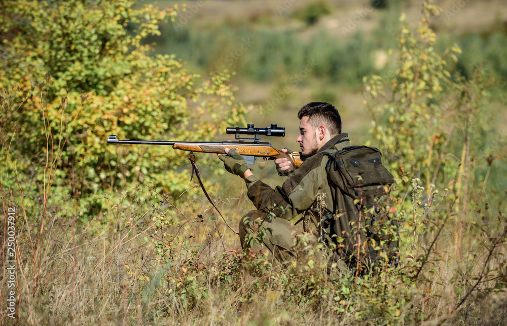 Hunting permit. Hunting equipment for professionals. Hunting is brutal masculine hobby. Bearded serious hunter spend leisure hunting. Hunter hold rifle. Man wear camouflage clothes nature background