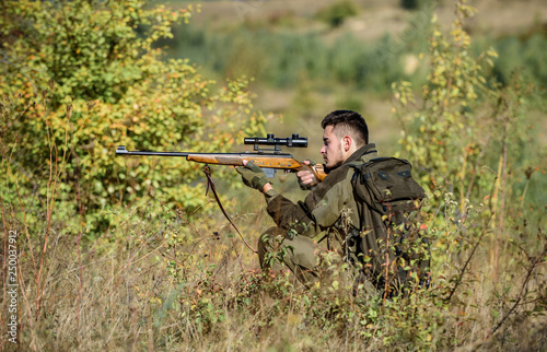 Hunting permit. Hunting equipment for professionals. Hunting is brutal masculine hobby. Bearded serious hunter spend leisure hunting. Hunter hold rifle. Man wear camouflage clothes nature background