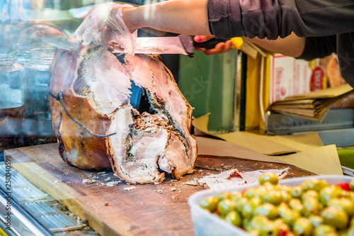 The traditional porchetta of Ariccia on the counter of a street vendor (street food). A woman slices the pork to make a sandwich. Frascati, Ariccia, Rome, Lazio, Italy, Castelli Romani, Roman Castles