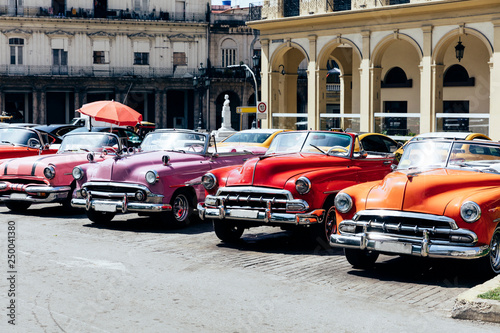 Fototapeta Naklejka Na Ścianę i Meble -  Vintage american cars parked on the street near Central Park in downtown Havana,
