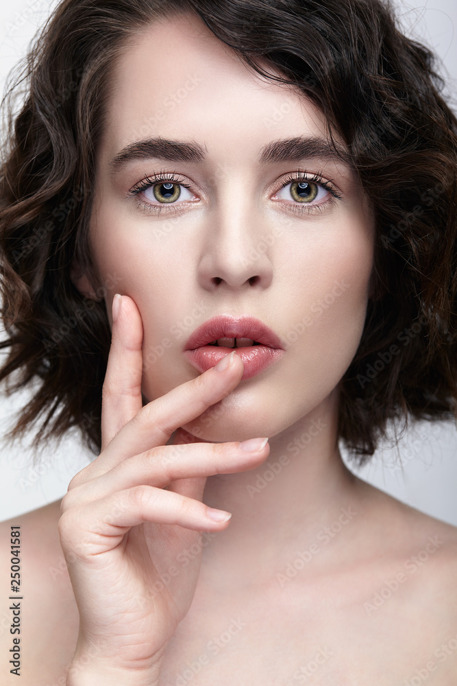Closeup beauty portrait of young woman with hands near face