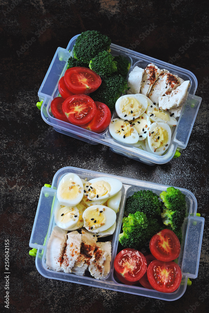 Lunch boxes with a healthy meal. Fitness snack in lunch box. Broccoli,  quail eggs, chicken breast and cherry tomatoes. Photos | Adobe Stock