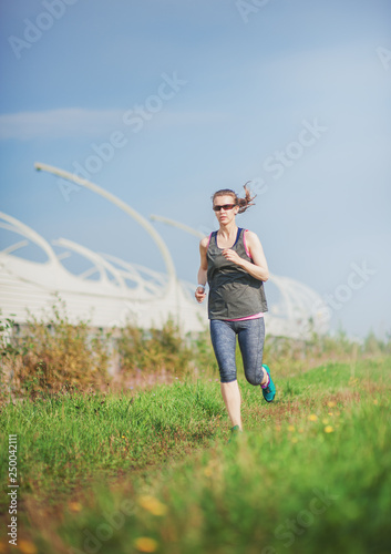 Active beautiful woman running in the city park. Healthy lifestyle © darkbird