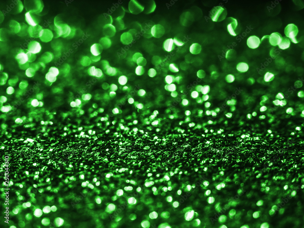 Background sequin. Green background. Holiday abstract glitter background with blinking lights. Fabric sequins in bright colors. Fashion fabric glitter, sequins. Defocused. 