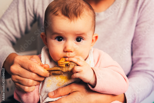 5 month old baby eating a chicken leg using the Baby led weaning BLW method.