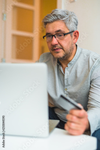 close up view of middle aged man shopping online at his home