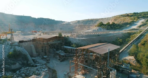 Aerial view industrial of opencast mining quarry with lots of machinery at work. Extraction of gold, copper.