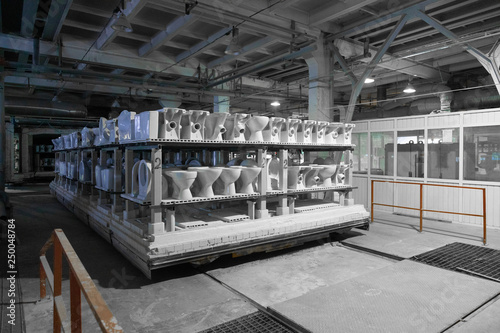 ceramic toilets and sinks on the shelves in the production shop photo