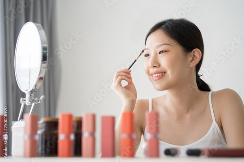 Young Asian female makeup beauty by eyebrow brush