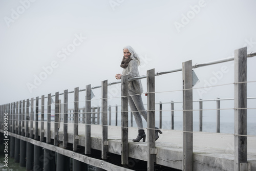 mature serene woman leaning at a pier smiling