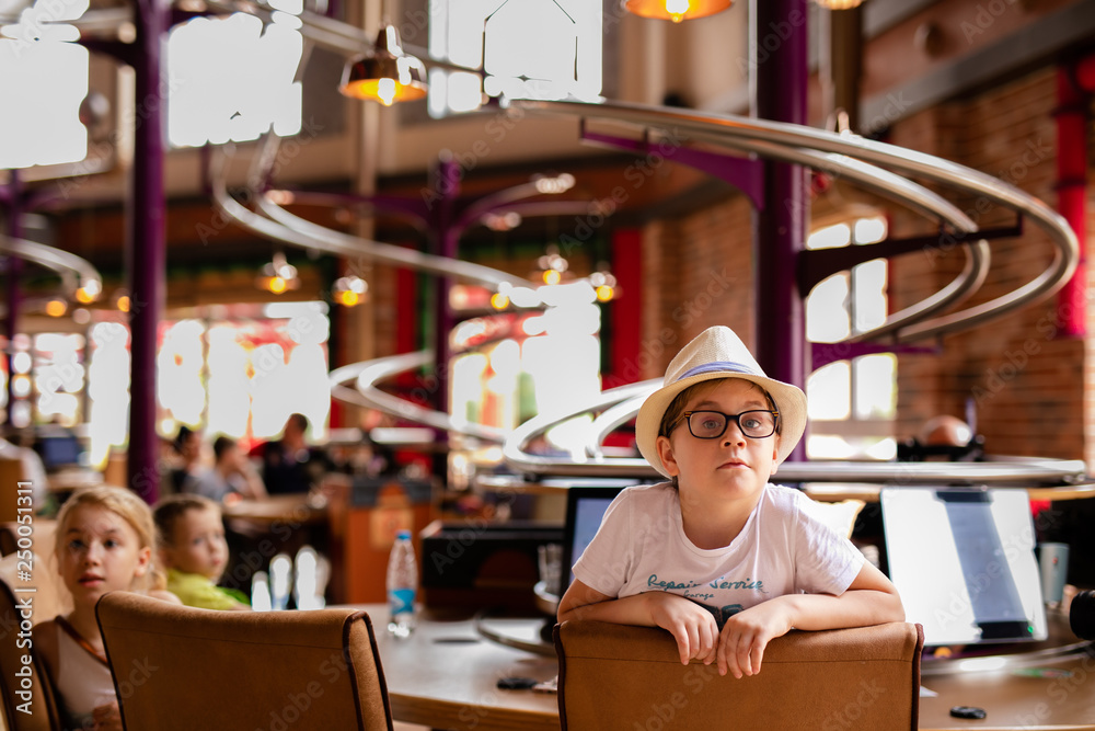 Restaurant and boy in the funny hat in the enterteiment park. RUSSIA, SOCHI, Sochi-park, june 2018