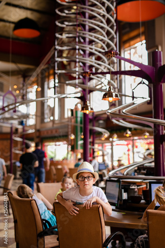 Restaurant and boy in the funny hat in the enterteiment park. RUSSIA  SOCHI  Sochi-park  june 2018