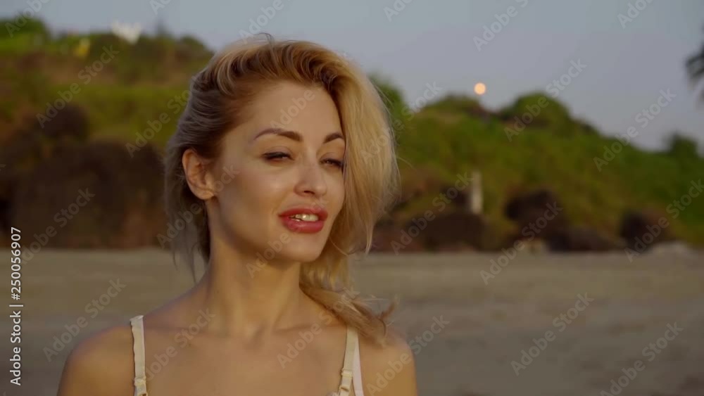 portrait of a smiling blonde on the background of an exotic evening beach. portrait of a smiling blonde on the background of an exotic evening beach.