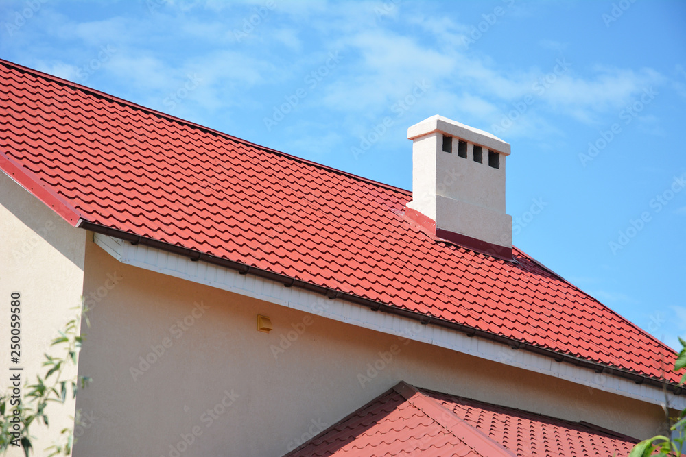 Red metal tile roof. Metal house red color rooftop with chimney.