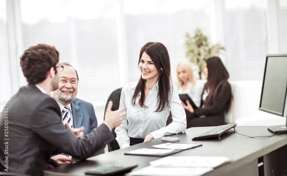 boss and members of the business team sitting at workplace on background of office boss and members of the business team sitting at workplace on background of office
