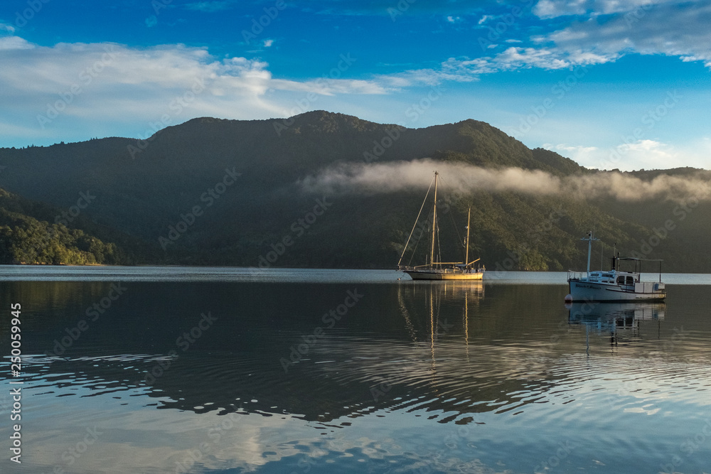 Boats sitting on flat calm waters of the the Marlborough Sound