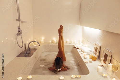 Woman relaxing in bath with candles Fototapeta