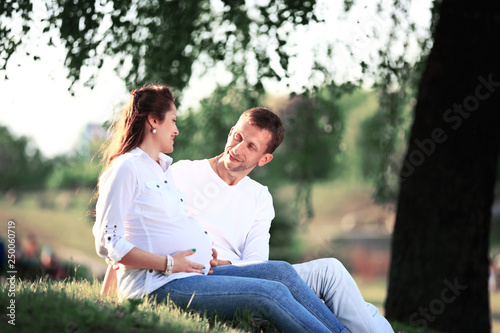 pregnant woman with husband in the Park. Riendly, cheerful family having a picnic. © yurolaitsalbert