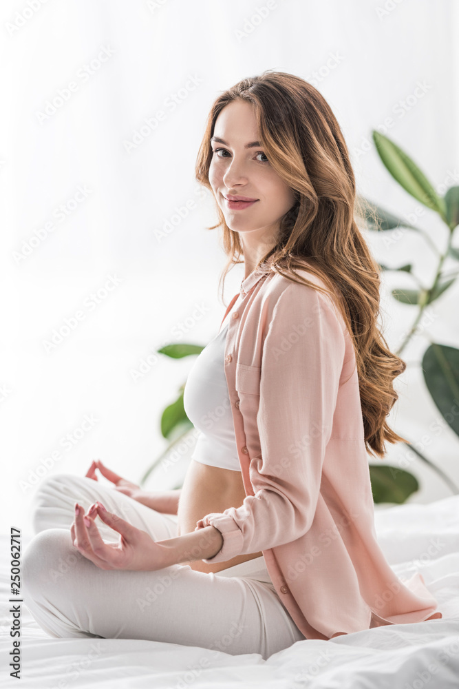 Beautiful pregnant woman meditating and looking at camera Beautiful pregnant woman meditating and looking at camera