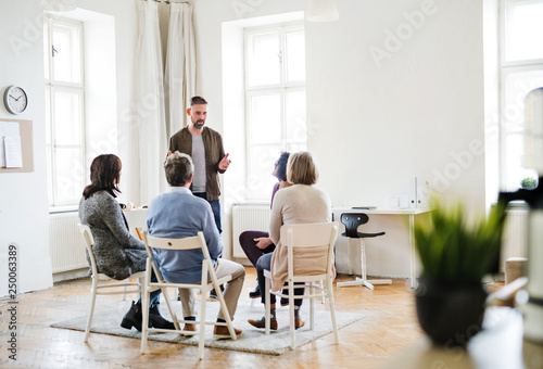 A man talking to other people during group therapy.