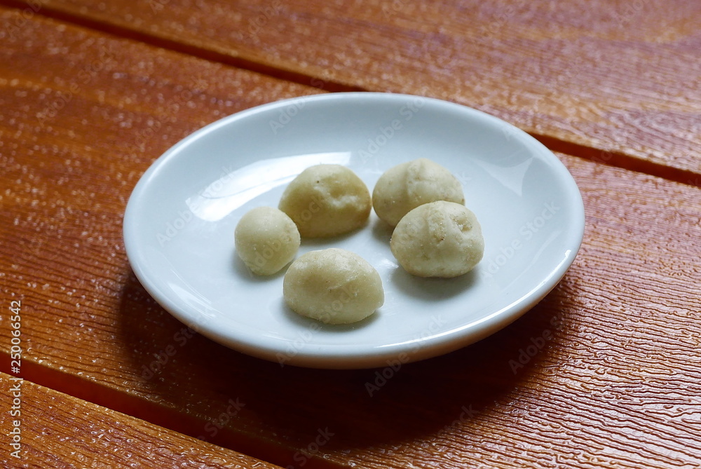 Top view of macadamia nuts in bowl on wooden background. Top view of macadamia nuts in bowl on wooden background.