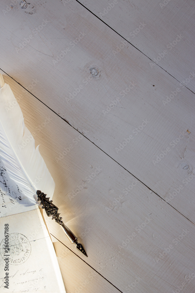 White wooden surface for your text, copy past and mock up for romanic and poetry design. Vintage feather, old style, writing materials.