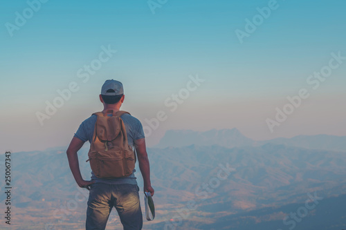 Young Man Traveler with map backpack relaxing outdoor with rocky mountains on background Summer vacations and Lifestyle hiking concept © EKKAPON