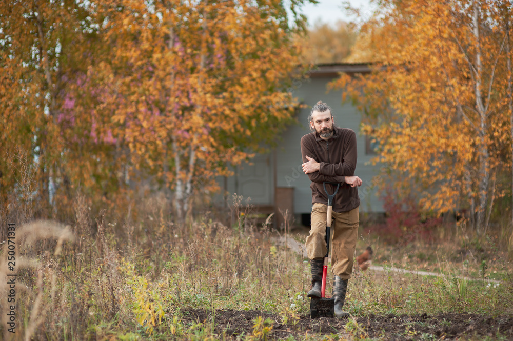 the man with the shovel - bearded farmer with a shovel looking in the frame the man with the shovel - bearded farmer with a shovel looking in the frame