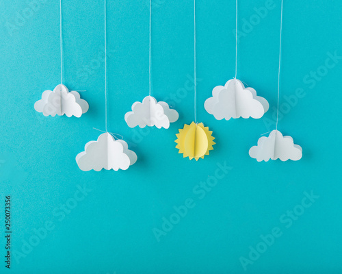 Blue background paper with white clouds on a string, minimalism