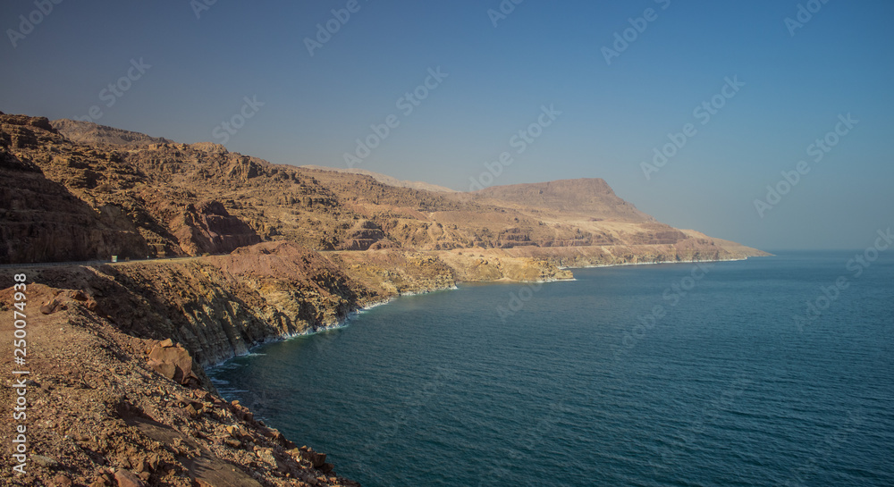 Middle East desert bare mountain ridge in perspective foreshortening along dead sea shoreline, panorama photography