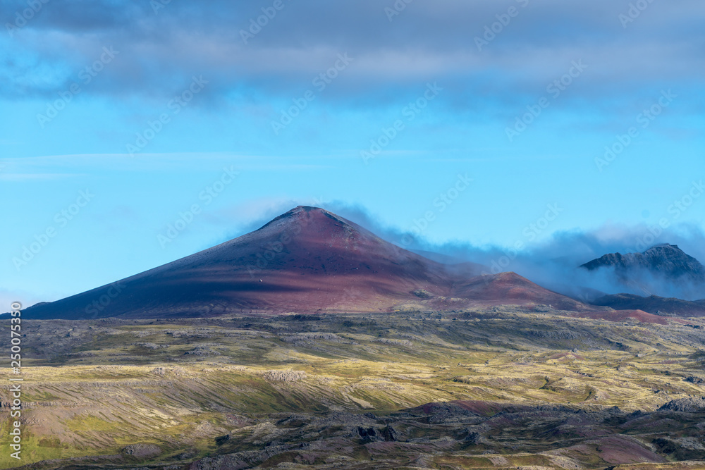 Volcano peak in Iceland with petrified lave field in front