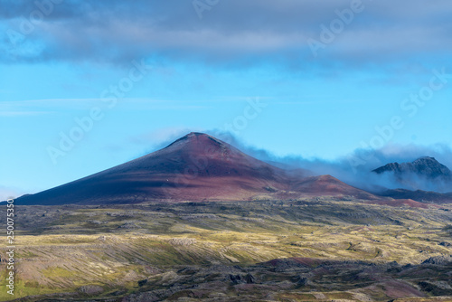 Volcano peak in Iceland with petrified lave field in front