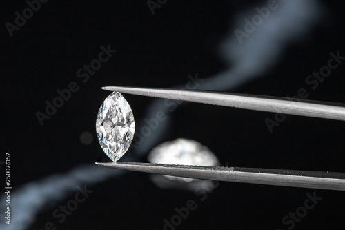 marquise diamond with tweezer on black background photo