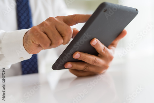 Close up of middle age business man using tablet